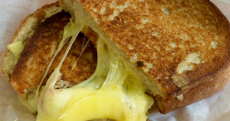 A delicious grilled cheese sandwich with gooey melted cheese oozing from toasted bread, perfect for a cozy meal.