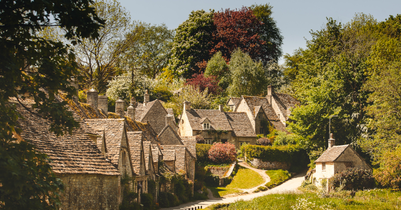cotswold village full of small cottages with lush greenery around