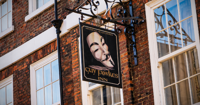 a sign hanging from a building that says Guy Fawkes Inn