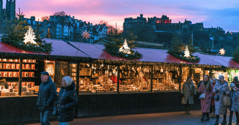 People wandering a Christmas Market at sunset