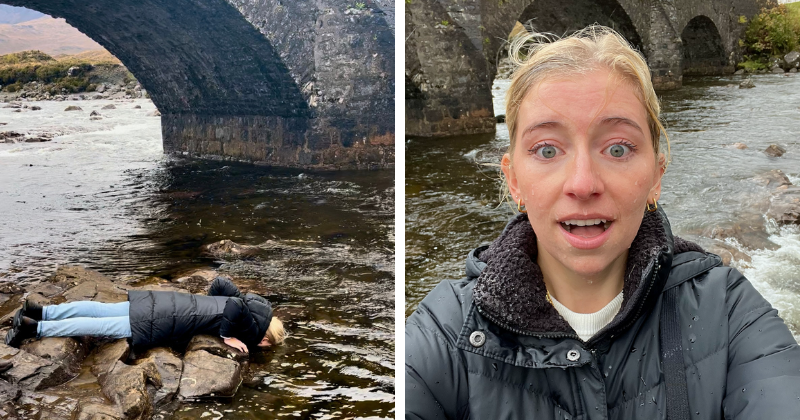 A woman lying on stones and dunking her face in a river, and a woman looking surprised with a wet face
