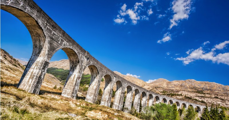 a stone viaduct surrounded by mountains