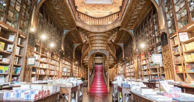 an old library with a grand red staircase