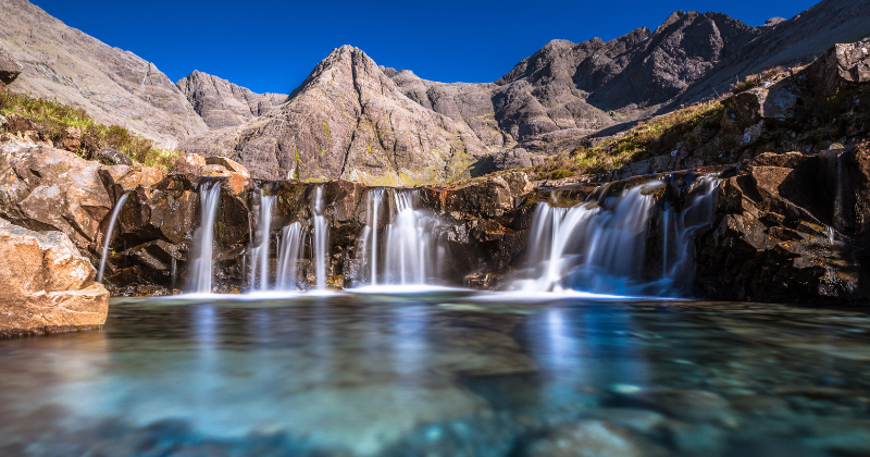 waterfalls going into a pool of water