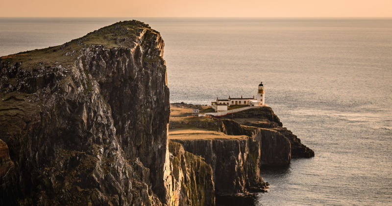 a lighthouse on a cliff in front of the ocean
