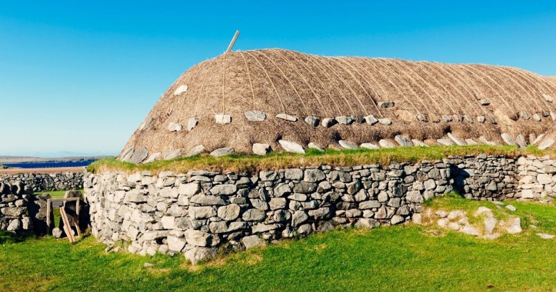 a stone house with a thatched roof