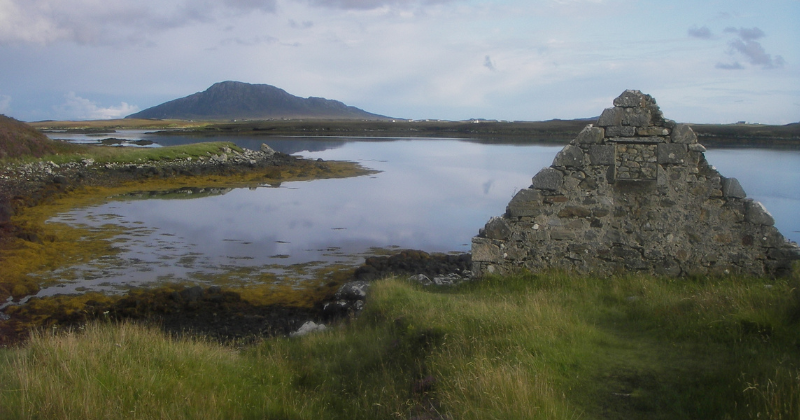 a stone ruin in front of a lake