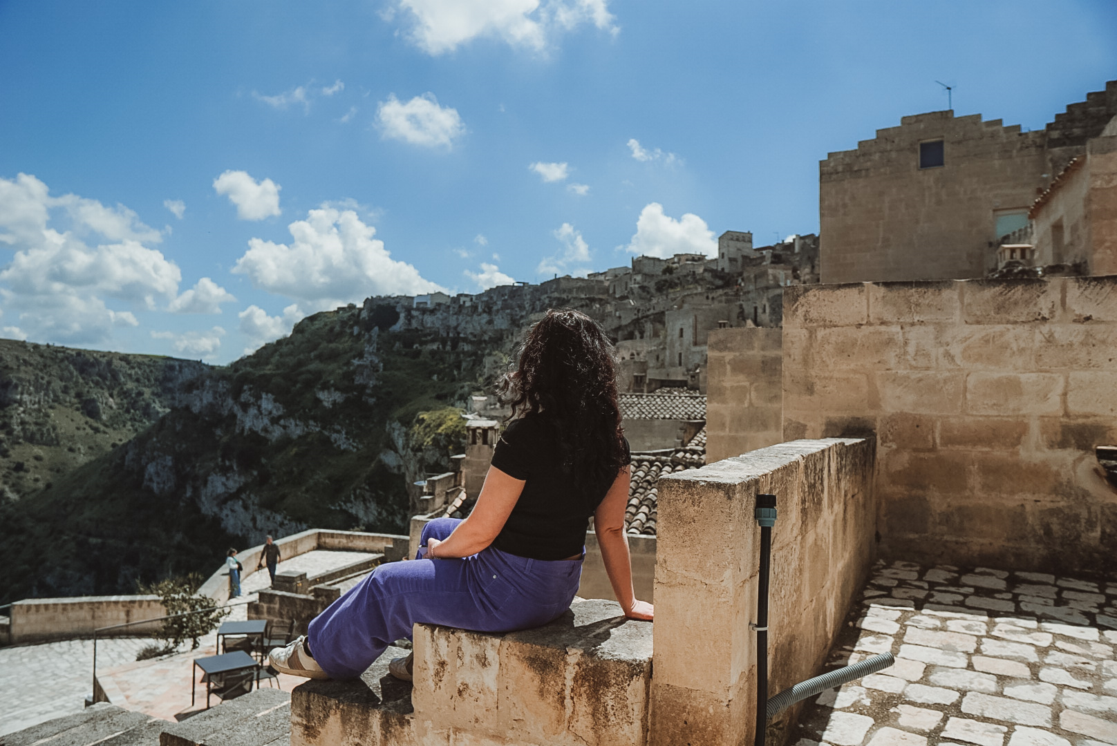 woman sat on steps overlooking the view of italian mountains