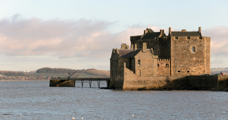 a stone castle sitting on the water front
