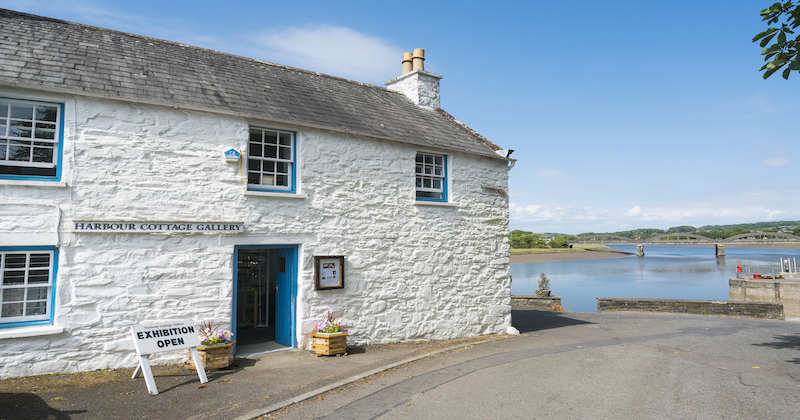 a white cottage by the water