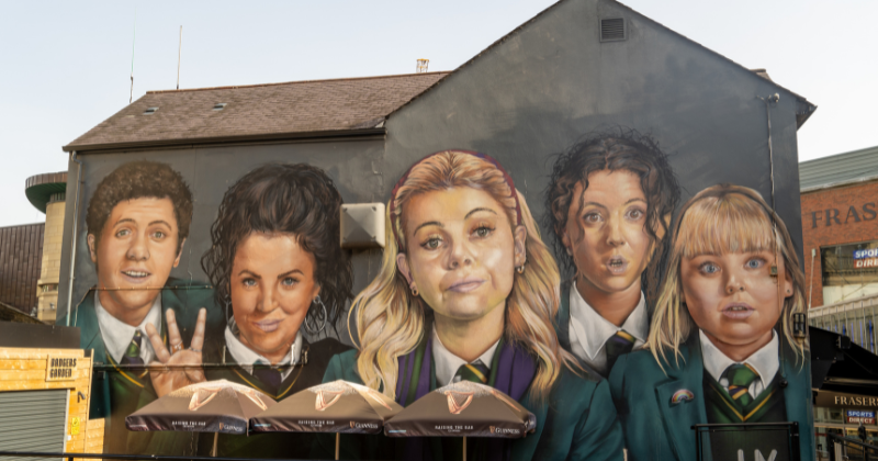 side of a building with the characters of Derry girls painted on the side