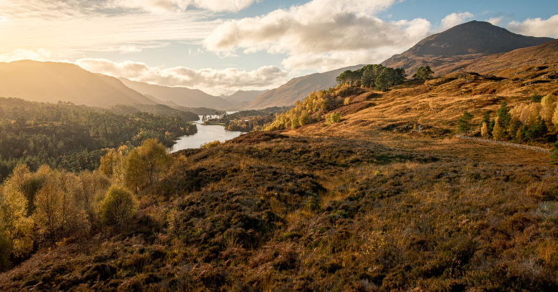 a valley and river at sunset