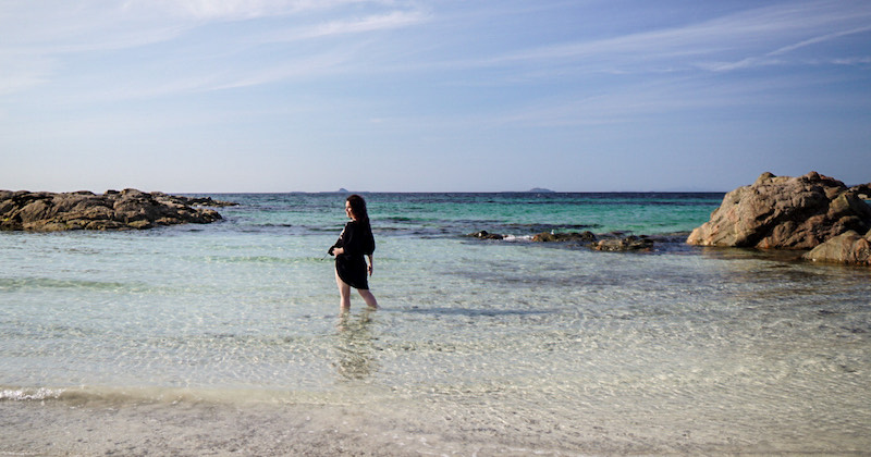 woman in the sea to her knees with blue sky above