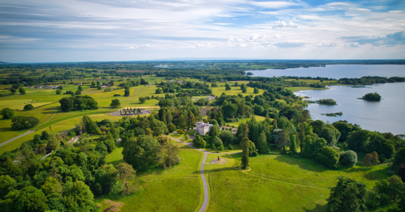 birdseye view over green landscape with a blue lake to the right hand side