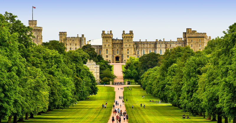 the Royal Mile leading up to windsor castle surrounded by green trees and people walking along the path