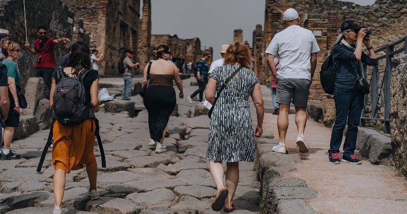 group of people walking the ruins of Pompeii