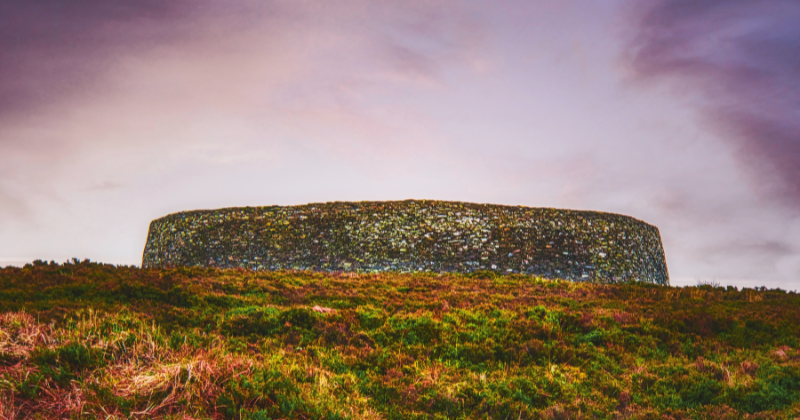 circular stone with a purple hue sky above and moss grass below