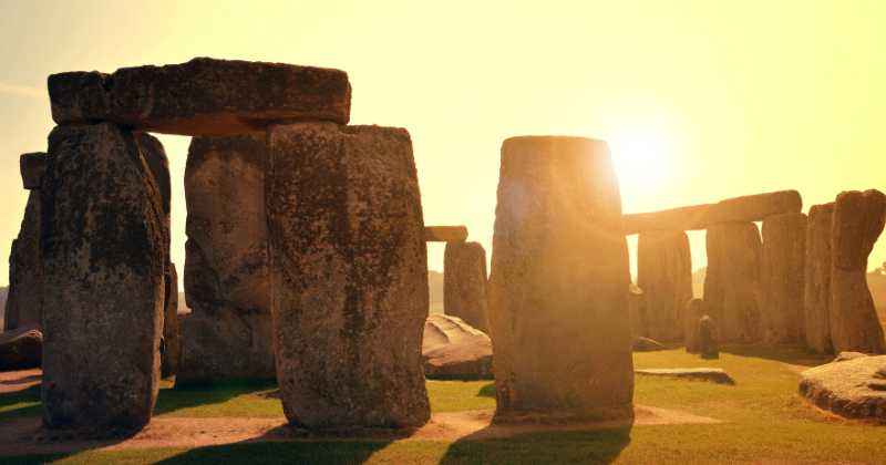 Stonehenge standing stones with a golden sun shining through