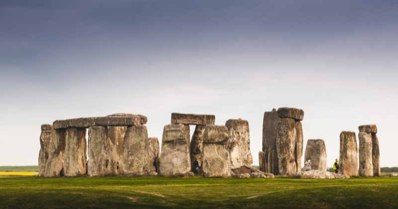 Stonehenge standing stones with green grass and blue sky above