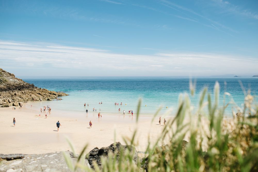 cornwall beach with people playing in the sea