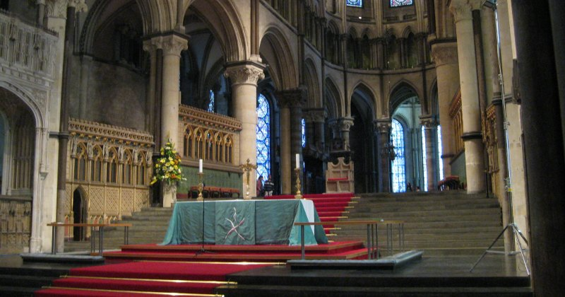 inside the cathedral with steps and a pew in the centre