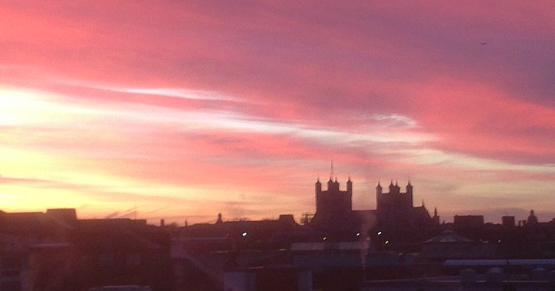 pink and red hue sky over the tops of rooftops