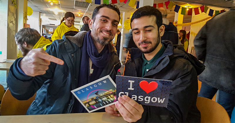 two men looking at postcards from Glasgow