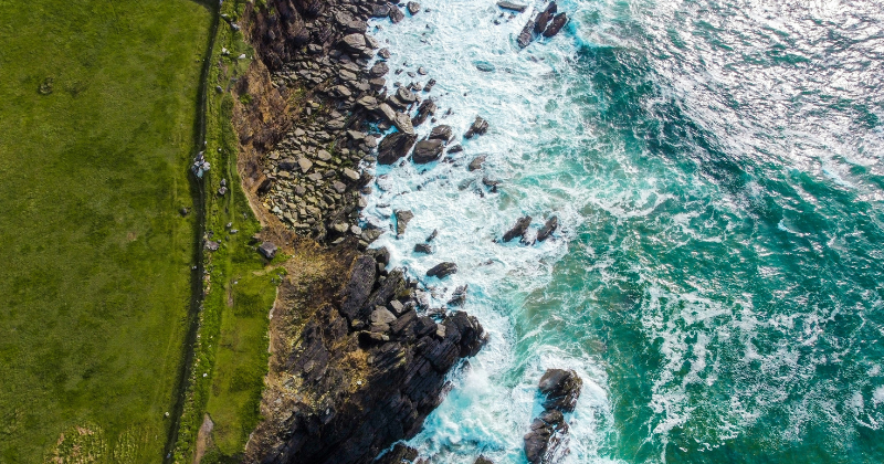birds eye view of a green coastline and the ocean