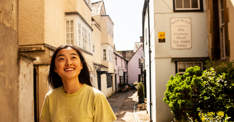 woman smiling as she roams the streets of Oxford