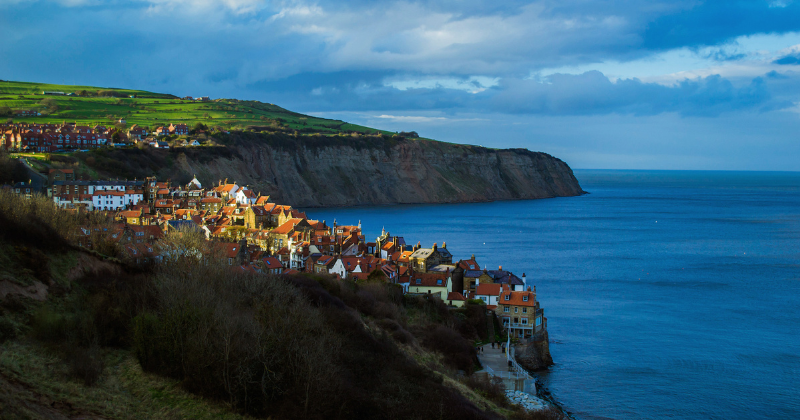 robin hood bay with blue water to the right and a bay of houses lining the coast