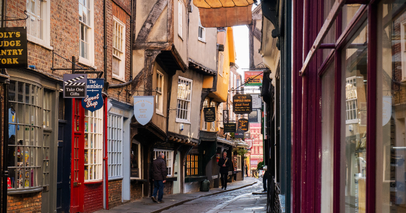 narrow shopping street with signs hanging high