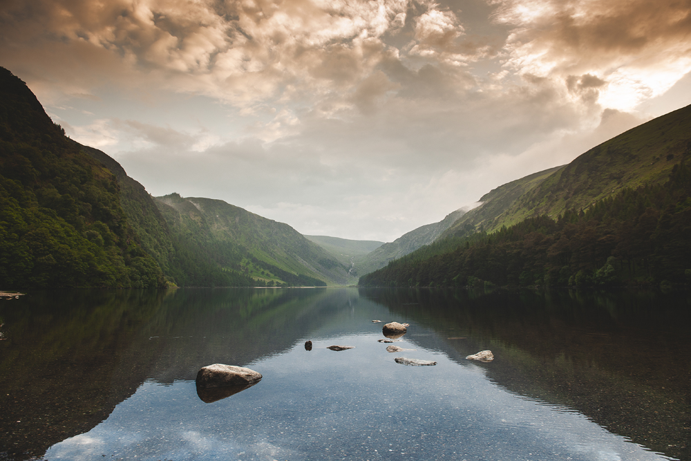 a dark lake running through the middle with mountains on either side of the banks