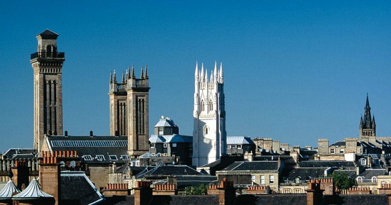 Skyline showcasing a mix of historic architecture, including towers and spires, under a clear blue sky. Ideal for UK tours.