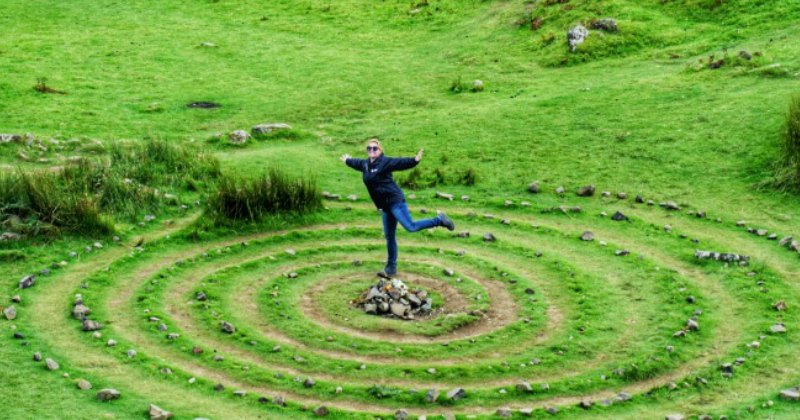 a woman standing on stones surrounded by a ring of stones
