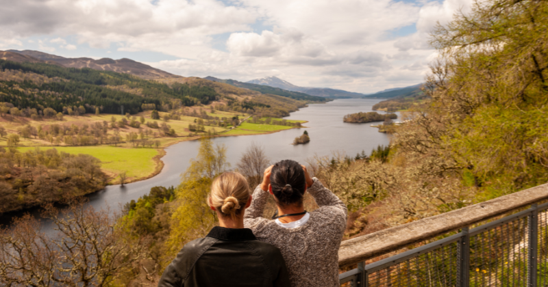two people overlooking a loch