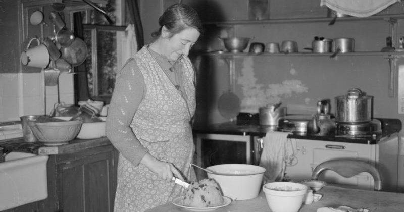 black and white image of woman in kitchen cooking