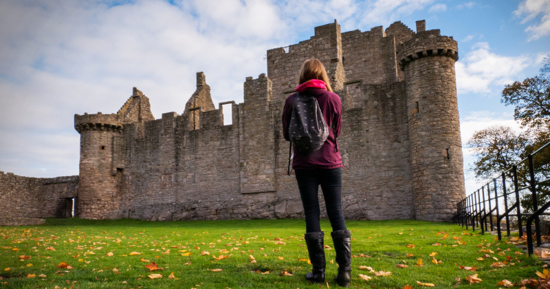 a woman standing in front of a castle