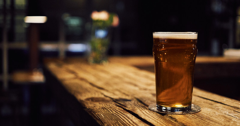 pint of beer resting on top of a bar top